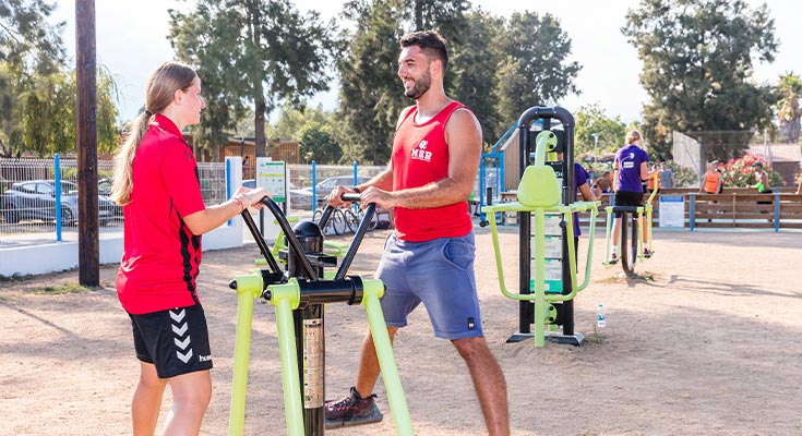 animateur aidant un client à la salle de sport de plein air du camping